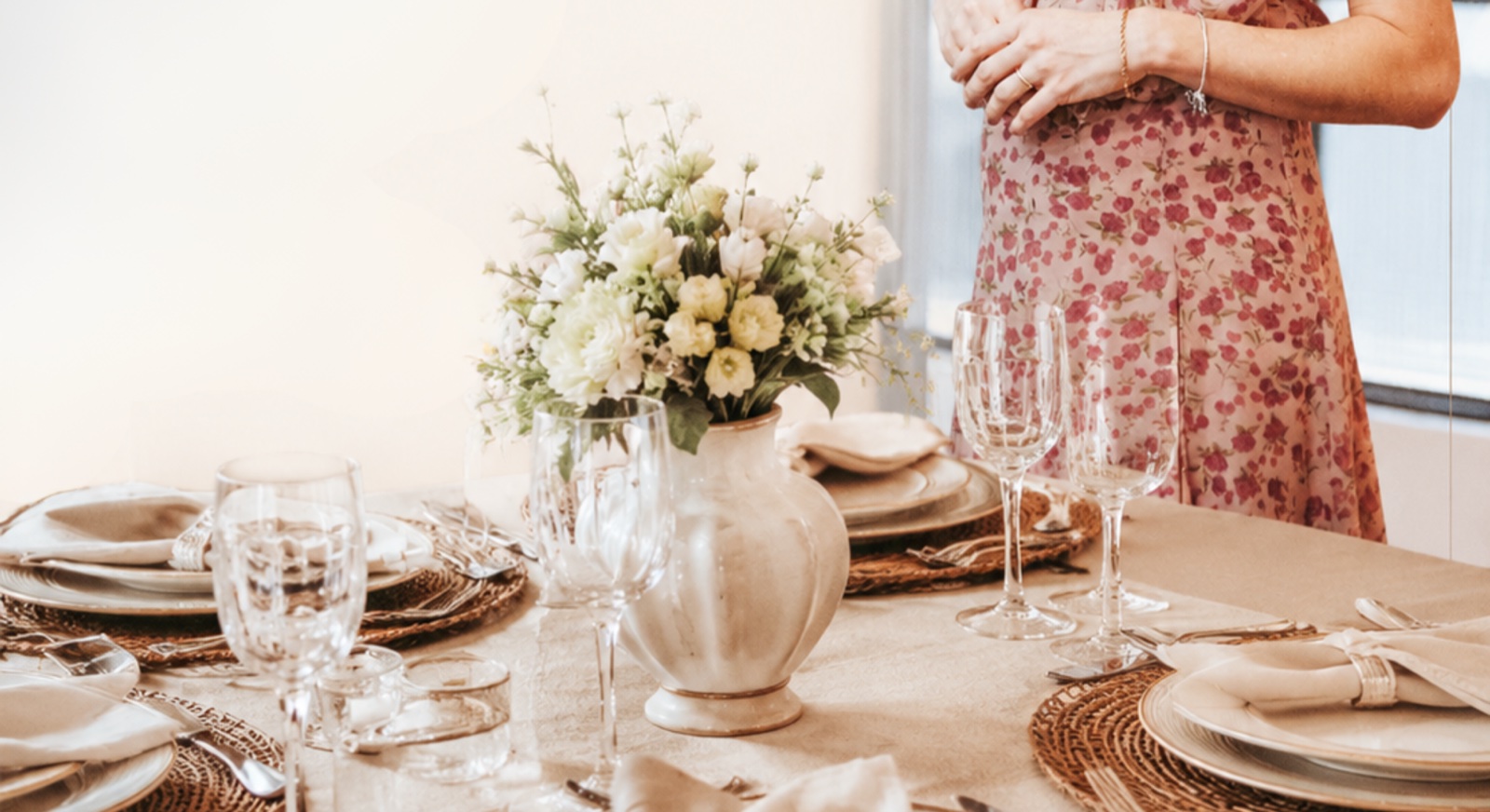 Mesa posta por Caroline Berri, com toalha de linho, flores brancas e taças de cristal, montada para o curso À Mesa